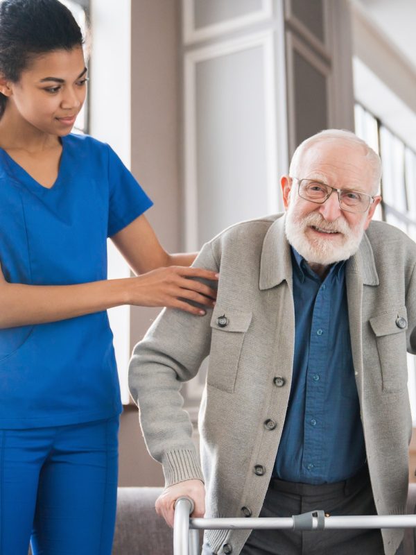 handicapped-man-using-walker-rehabilitation-at-home-nurse-helping-disabled-man-using-walker.jpg